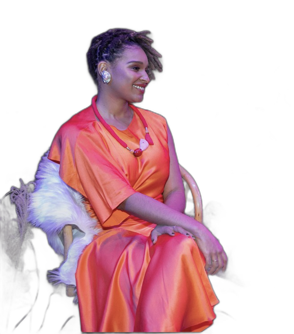 Portrait of Dyandra Raye, founder of Jo-Anne Vernay, seated in a coral-orange look